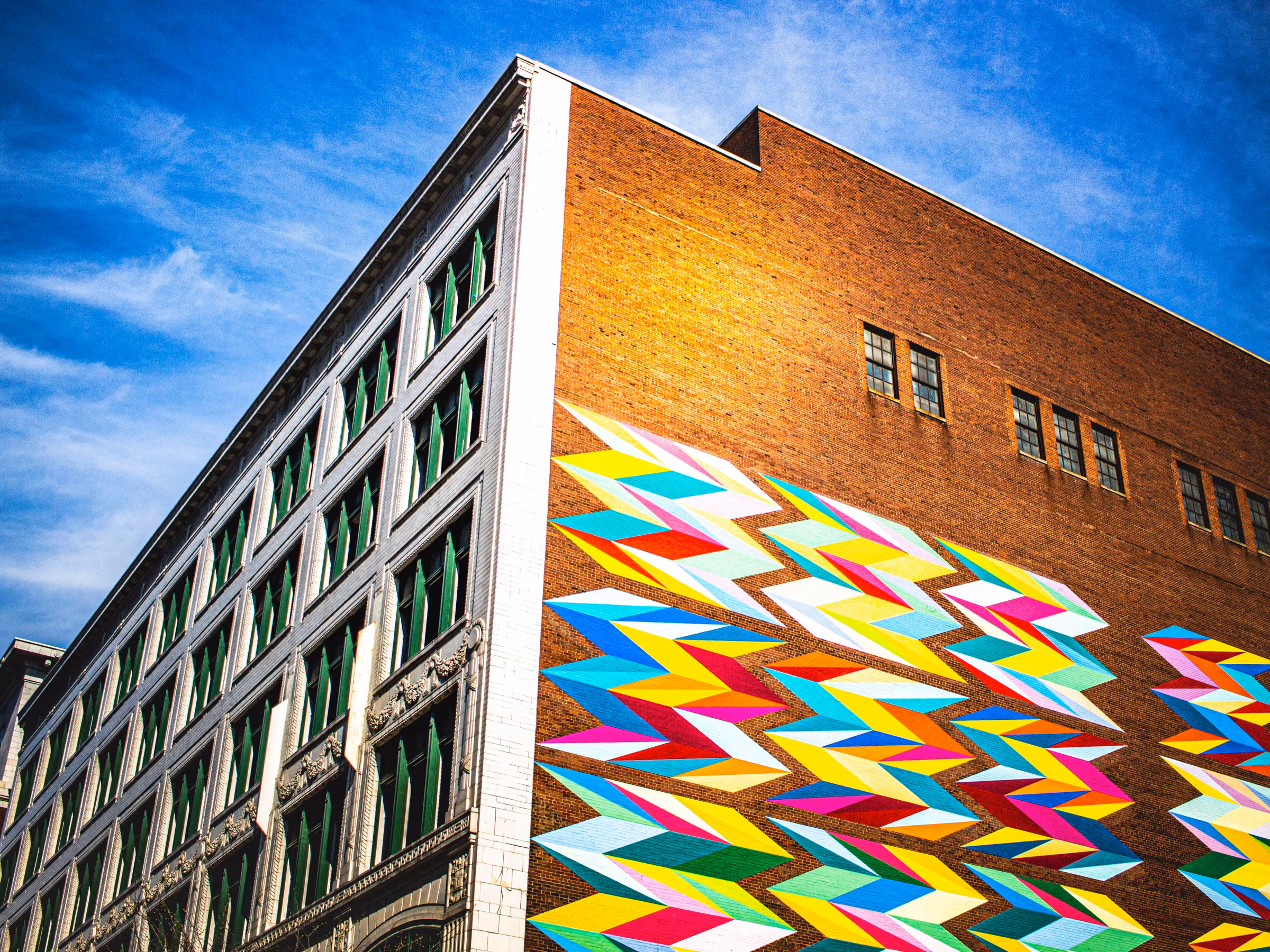 Historic brick multi-family building with a vibrant mural in Cleveland